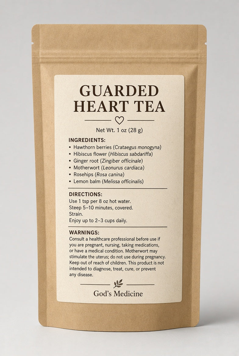 A single stand-up pouch of God's Medicine Guarded Heart Tea in a kraft paper package with a large cream label showing the tea name, ingredients, directions, and warnings on a light gray background.

